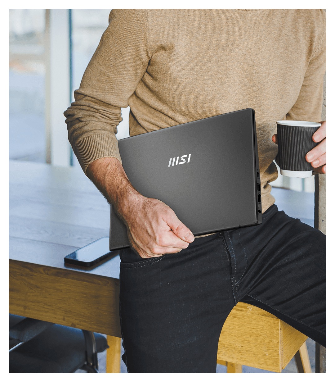 Laptop MSI Modern 15 F13MG-443PL Intel Core i5-1334U 15.6” FHD 16GB/512GB srebrny trzymany przez mężczyznę w ręku